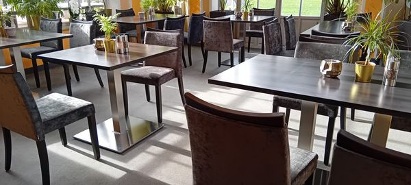Restaurační čalouněné židle a kovové bistro stoly